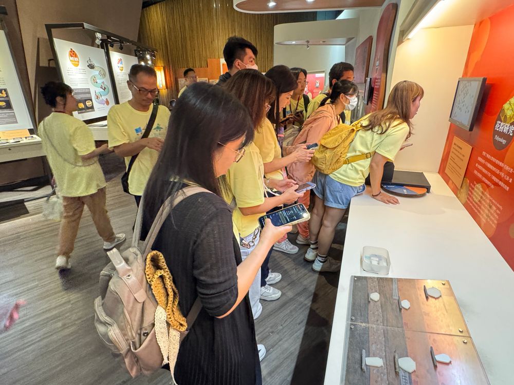 在考古工作站，學員動手操作觀察工具細看出土標本，一旁對照「十三行人的陶土配方」展板，用微觀線索破解第一關。（照片提供者：新北市教育局 / 拍攝日期：2026.08.11）